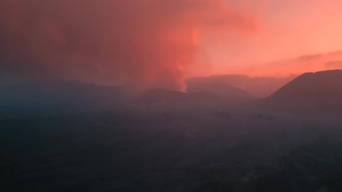 Epic Pink Sunset with Clouds and Smoking Mount Bromo Volcano at EastJava Indonesia Aerial Drone View