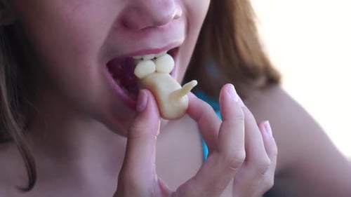 Closeup of a Girl Eating a Unicorn Shaped Candy