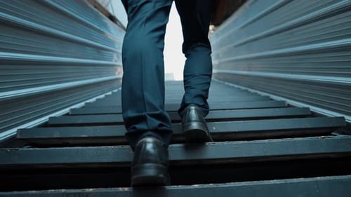 Man in Suit Walking Up Urban Exterior Metal Stairs