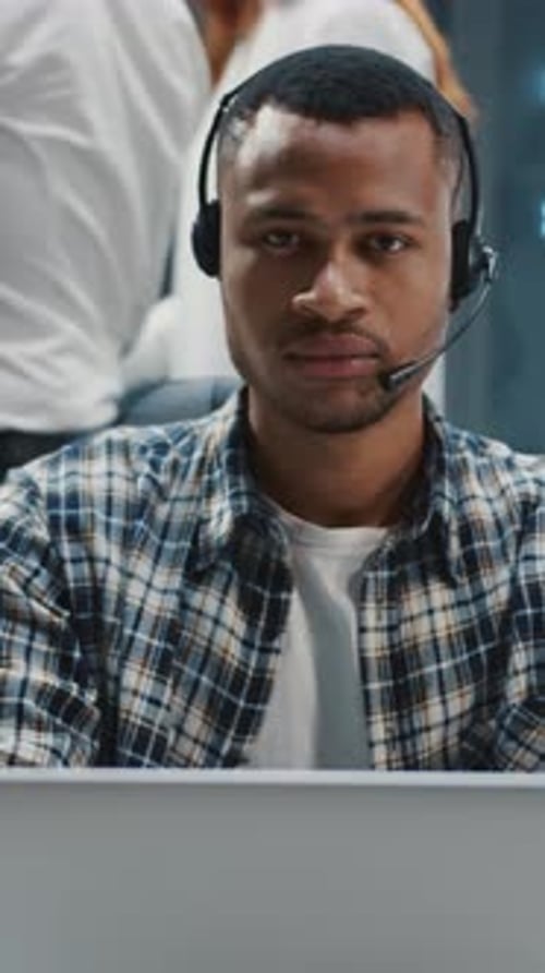 Man in headset works at laptop in data center