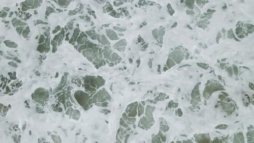 Aerial View of Foamy Waves Crashing on Shore