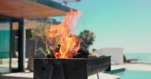 Empty, outdoor and bbq with flame in backyard for party, holiday and lunch on weekend by poolside