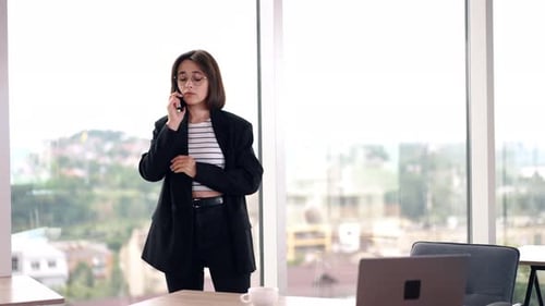 Lady standing at the office window waiting patiently for the response on her call. business, beautif