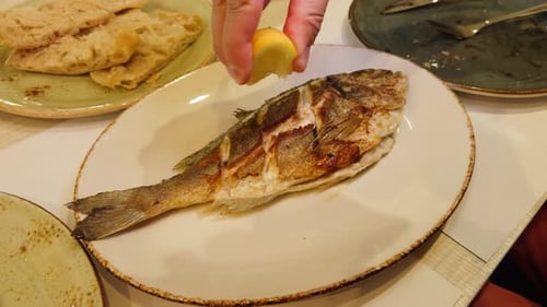 Fried Dorado Fish Close Up Cooked Fish on a Grill Barbecue with Lemon Wedges in a Seafood Restaurant