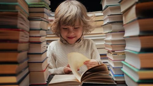 Handsome Little Child Flips Through the Book Pages in Library Elementary School Boy Enjoying Reading