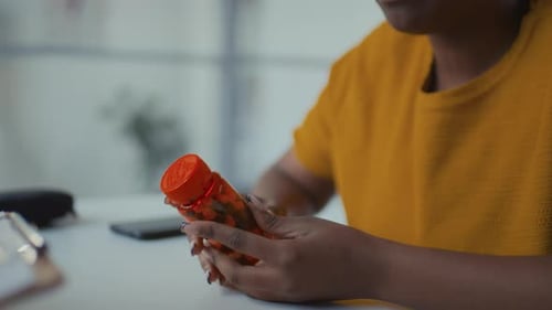 Young Adult Discussing Pills at Desk