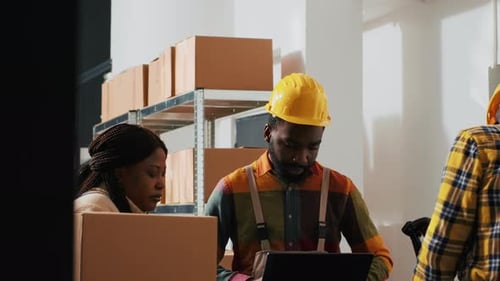 Warehouse Workers Scan Inventory Using Laptop