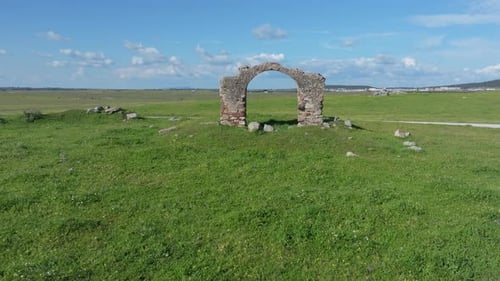 Vorwärtsflug der Drohne über einem alten Bogen aus Ziegeln und Steinen