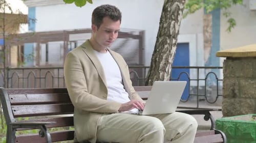 Young Man Working on Laptop Outdoor