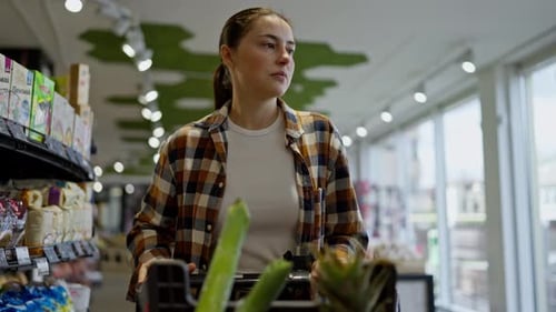 Woman Shopping in a Bright Supermarket Aisle
