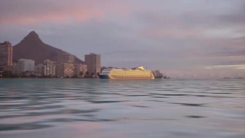 Luxury Cruise Ship Anchored Near a Coastal City Skyline and Dramatic Mountain