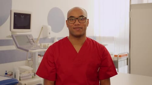 Doctor in red scrubs posing in a hospital