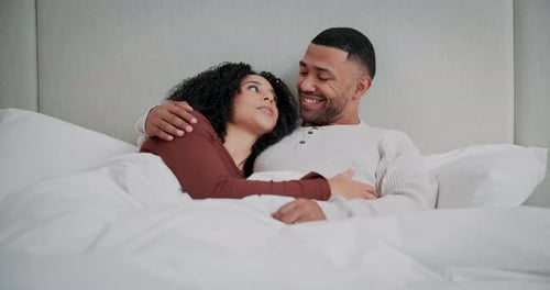 Happy Couple Embracing in Bed Together