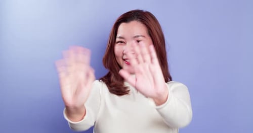 Woman Smiling and Waving Hello in Studio