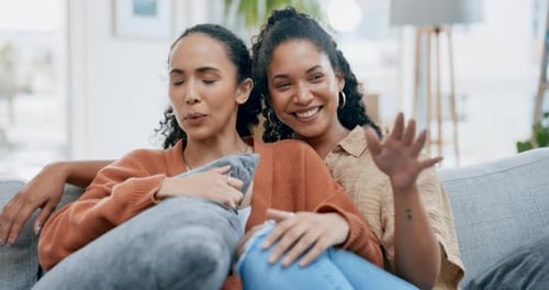 Two Women Relaxing on Couch Together Laughing