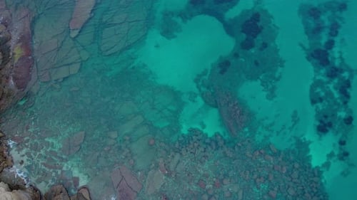 Rocks In The Seabed Visible In Shallow Turquoise Sea Water - Aerial Top Down