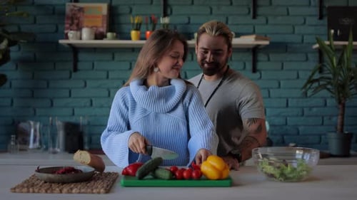 Young Couple Cooking and Smiling in Kitchen