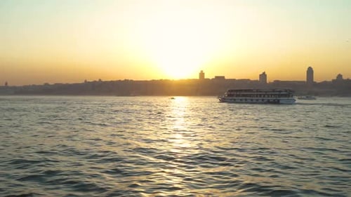 sunset over the Bosphorus strait in Istanbul city with boats and ferry