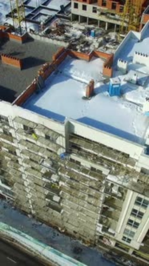 Construcción de edificio en invierno. Edificios altos en construcción con grúas
