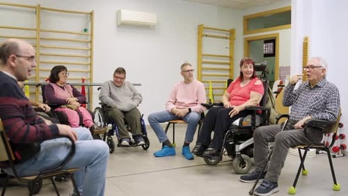 Adults in Wheelchairs Talk in Therapy Setting Indoors