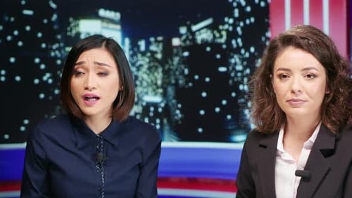 Two Women Presenters Talking at News Desk