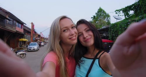 Smiling women take photos in ko lanta Thailand old town on summer vacation