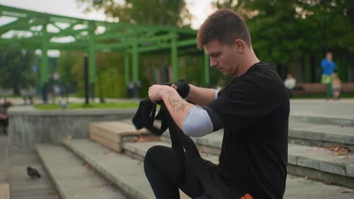 Man Wraps Hands Tattooed Youth Prepares Boxing Gear Trainer Guides Person in City Park Urban