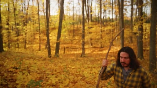 Un randonneur aux cheveux longs en automne s'arrête pour regarder autour de lui.
