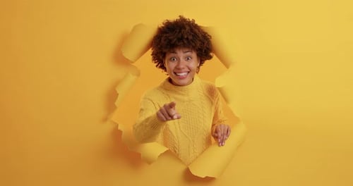 Positive dunkelhäutige junge Afroamerikanerin zeigt direkt in die Kamera und wählt Ihre Auswahl...