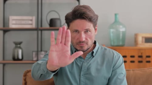 Stop Gesture by Middle Aged Man Sitting at Home