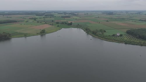 Aerial View Of A Serene Lake Surrounded By Lush Green Fields