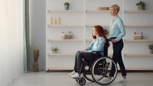 Woman Pushing a Wheelchair Indoors