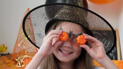 Girl Dressed as Witch with Pumpkin Decorations