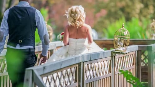 Bride and groom running on a wooden bridge. Beautiful wedding couple on the wooden bridge near the r