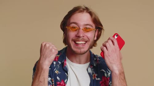 Excited Young Adult Celebrates Success on Phone