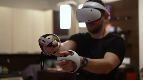 Man Using Virtual Reality Headset With Controllers