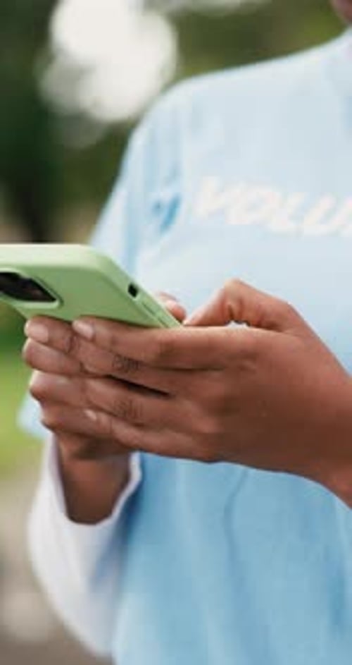 Volunteer, smartphone and woman in park, hands and program for charity, connection and typing