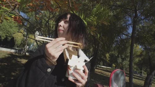 Girl With Longboard Enjoying Eating Wok And Chilling Close Up