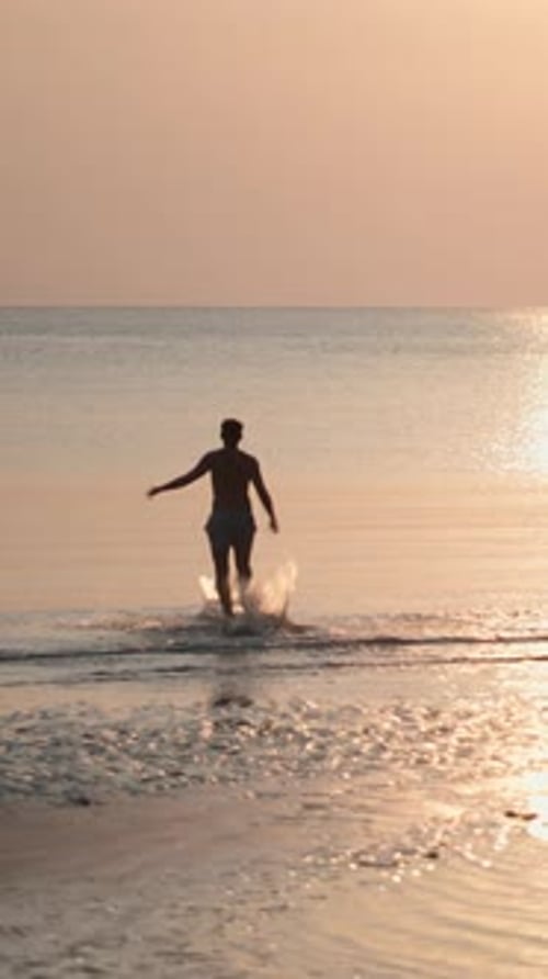 Young Adult Runs on Beach at Sunrise
