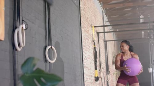 Exercising with medicine ball, woman training in gym for fitness workout, copy space