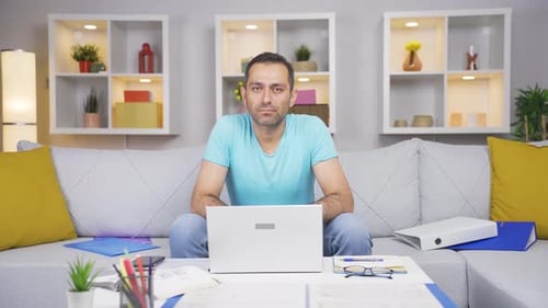 Home office worker man looking dull at camera.