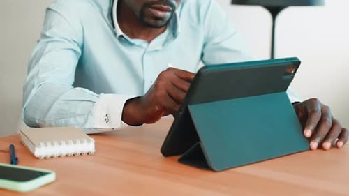 Man Working at Desk With Digital Tablet