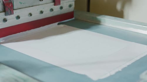 Machine silkscreen printing white ink onto material