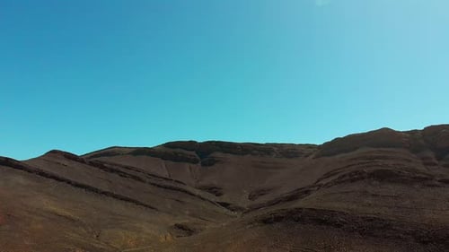 Aerial drone shot of mountain view on bright summer hot day displaying dry landscape.