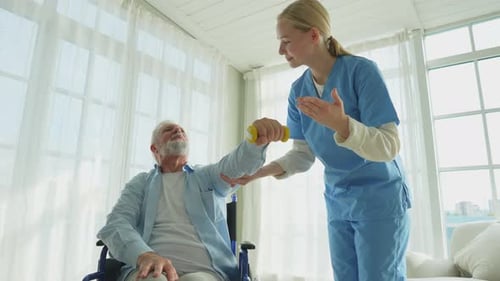 Female Caregiver Assists Senior Man with Dumbbell Exercise