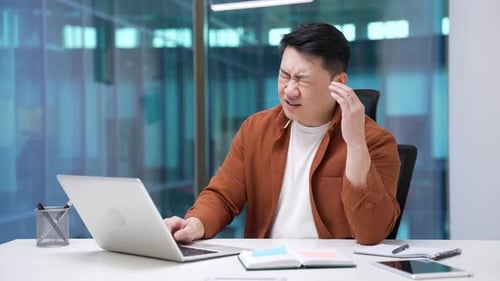 Man Working with a Headache in Office