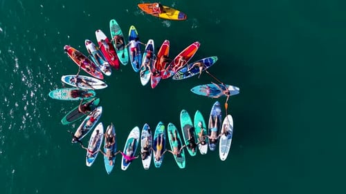 Festival de SUP com vista aérea em uma baía panorâmica: pessoas aproveitando o primeiro dia de verão