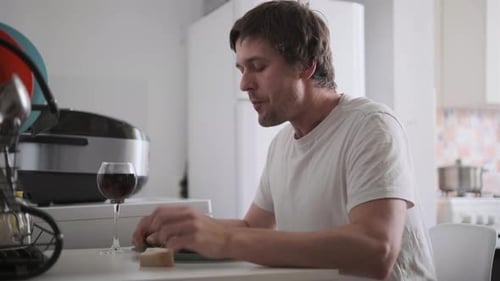 Man Eating Food and Drinking Wine Indoors