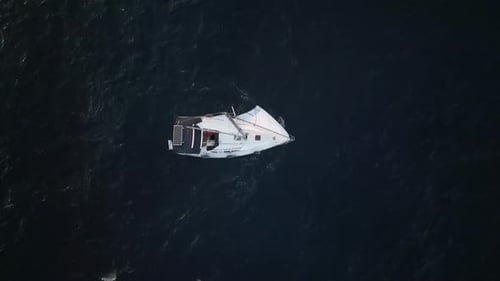 Luftaufnahmen über einem Segelboot mit offenen Segeln während des Sonnenuntergangs