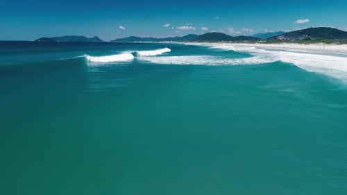 Brazilian Beach Aerial Flight Forward Over the Sea Surface with Perfect Waves Breaking on the